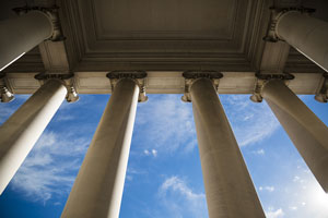 view of blue sky through columns of a government building
