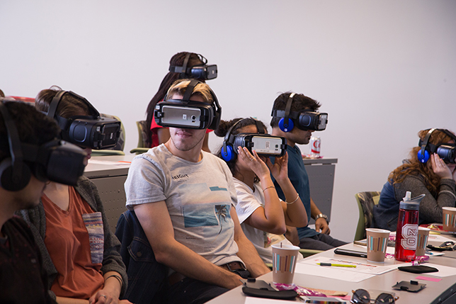 Students wear VR headsets to experience scenarios where cultural differences impact the way people communicate.