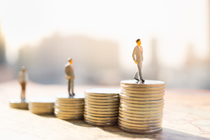 miniature people standing on stacks of coins