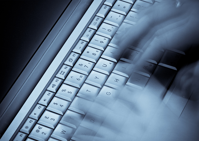 hands typing on a keyboard with motion blur