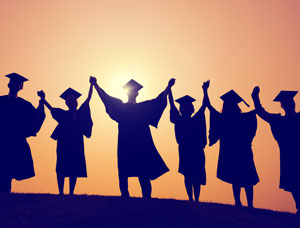 silhouette of college graduates with arms raised