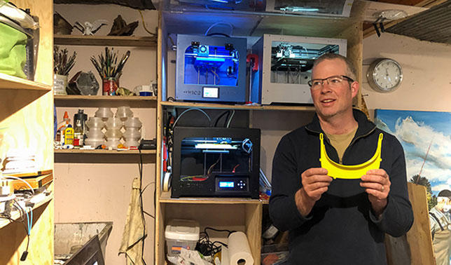 SUNY Canton Professor Matthew Burnett holds a piece of a face shield he printed in his own studio.