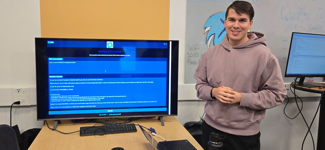 Anton Spiridonov, a senior at Bentley University majoring in Computer Information Systems, demonstrates his chatbot at a recent technology projects open house.