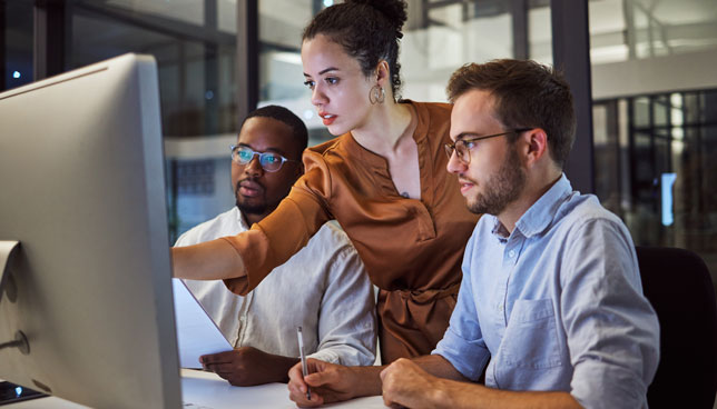 three coworkers collaborating at a computer