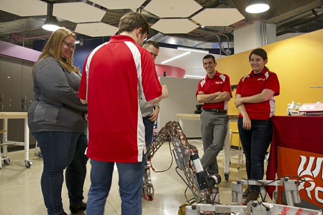 Georgia-Pacific's Arrine Lyman (left) discusses a planetary rover with the students who built it. Photo by David Tenenbaum.