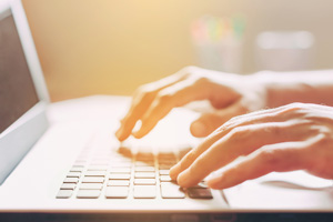 hands typing on laptop computer