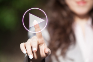 Hand of a woman touching play button on digital display