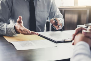 closeup of two people negotiating over documents