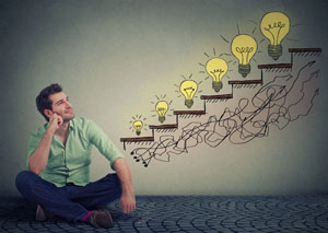 man looking up at growing lightbulbs