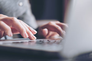 closeup of hands typing on laptop