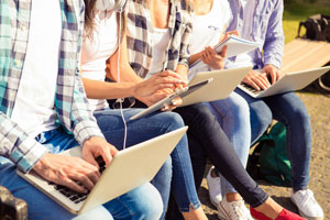 group of students using laptops and tablets