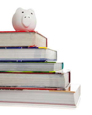 stack of textbooks with piggy bank on top