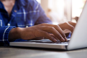 closeup of hands typing on laptop