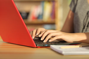 closeup of hands typing on laptop