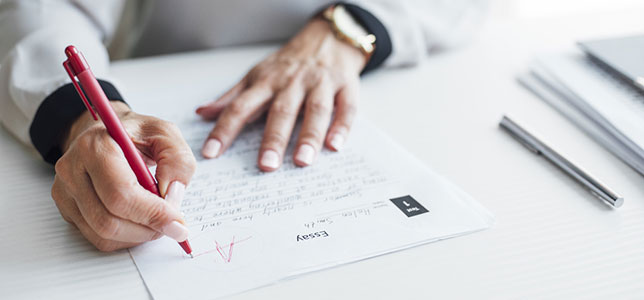 closeup of teacher grading a paper