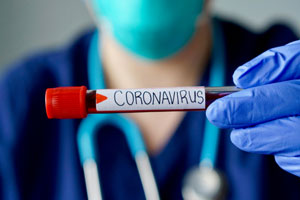 doctor holding up vial labeled coronavirus