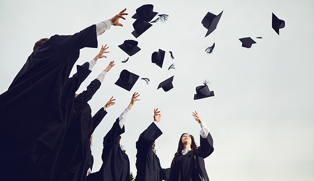 graduates throwing up their caps