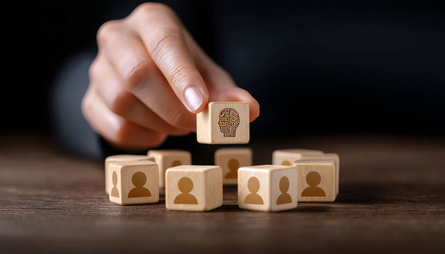 wooden blocks with human icons and artificial intelligence symbol