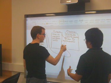  Students work together to design a database using the Smart Board in the CIS Sandbox.