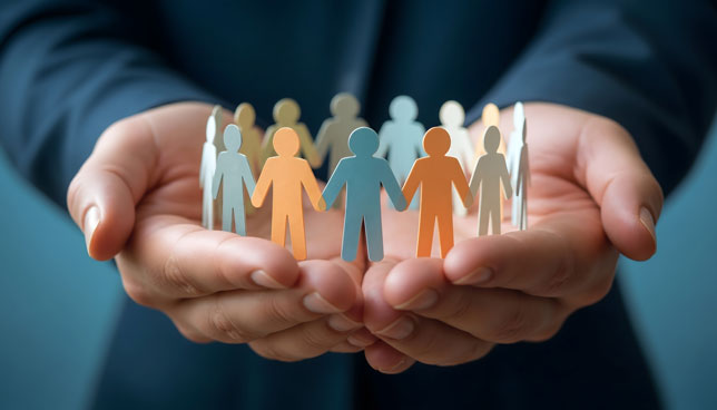 business person holding paper chain of people in his hands