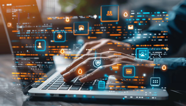 closeup of hands on laptop with various technology icons