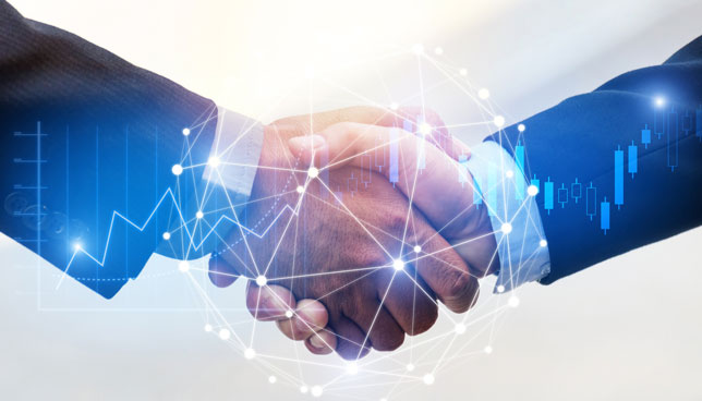 businessmen shaking hands behind digital technology imagery