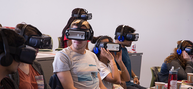 Students wear VR headsets to experience scenarios where cultural differences impact the way people communicate.
